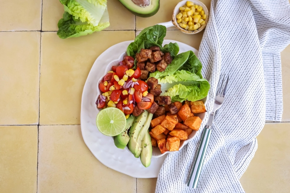 Zoete aardappel-tempeh bowl met maïssalade & avocado