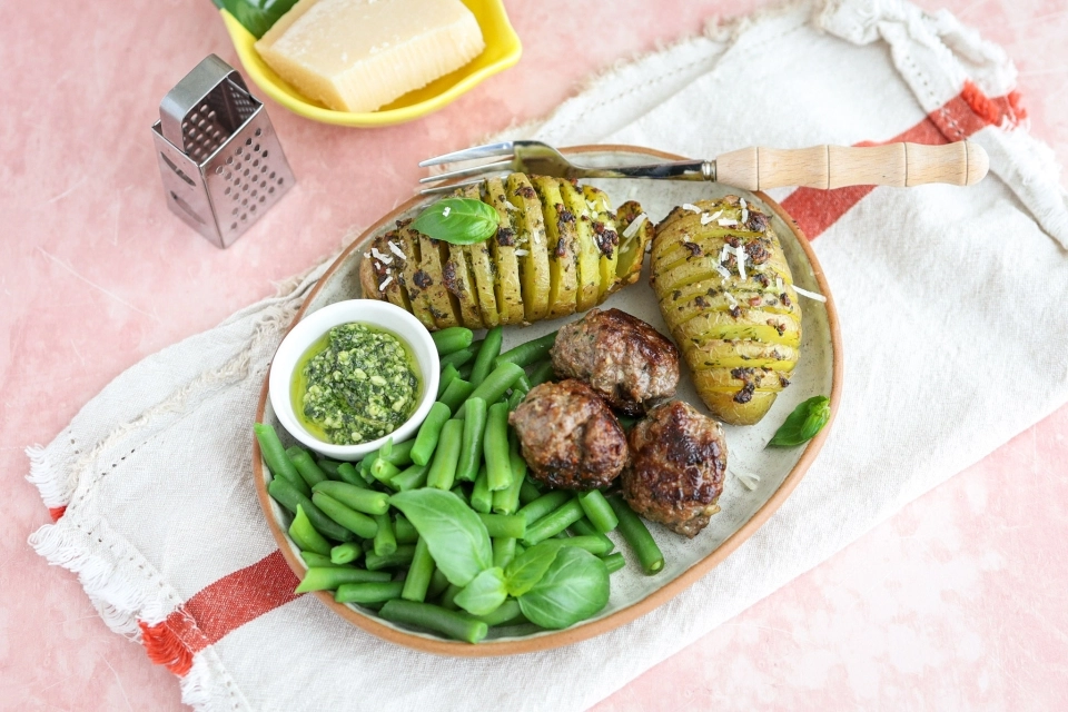 Hasselback aardappel met pesto, gehaktballetjes & sperziebonen